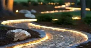 Curved garden pathway illuminated by modern LED strip lighting, enhancing nighttime visibility and aesthetic appeal in landscape design