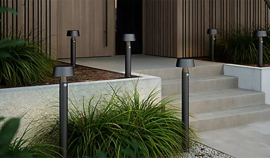 Modern home entrance with motion-sensor LED outdoor pathway bollard lights enhancing steps and landscaping safety in Raleigh, NC