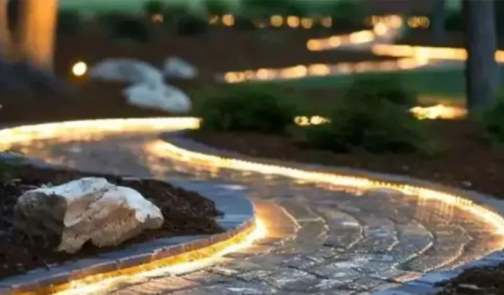 Curved garden pathway illuminated by modern LED strip lighting, enhancing nighttime visibility and aesthetic appeal in landscape design